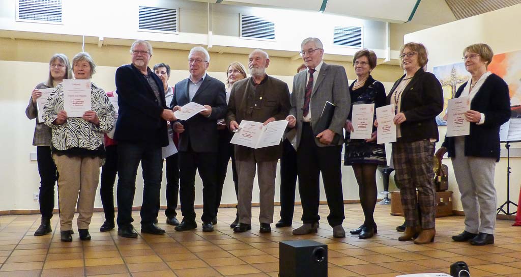 Die geehrten Mitglieder des MGV Windesheim am Abend des 29.12.2023 im evangelischen Gemeindehaus in Windesheim. Mit den Ausgezeichneten freuen sich Klaus Busch (3. von links), Sprecher des Team-Vorstandes des MGV, und Karl-Heinz Fassig (4. von rechts), stellvertretender Vorsitzender des Kreis-Chorverbands Bad Kreuznach.